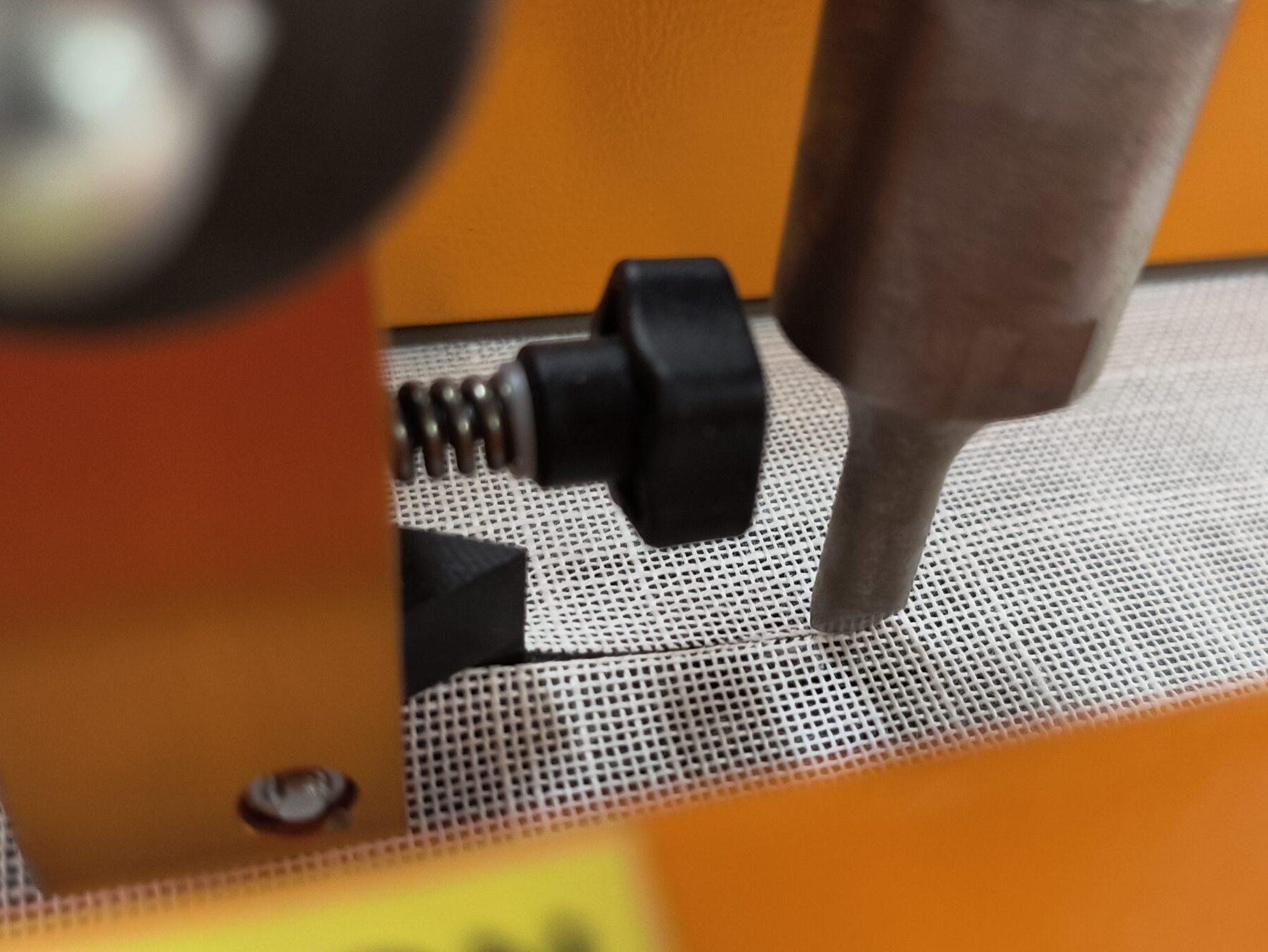 Ultrasonic cutting head trimming roller shade fabric in NYC workshop