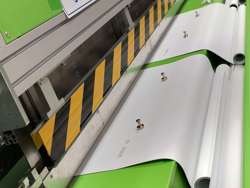 Custom roller shade fabric being precision‑cut and welded for nationwide shipping.