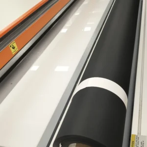 Black blackout roller shade fabric being precision cut in Brooklyn NY