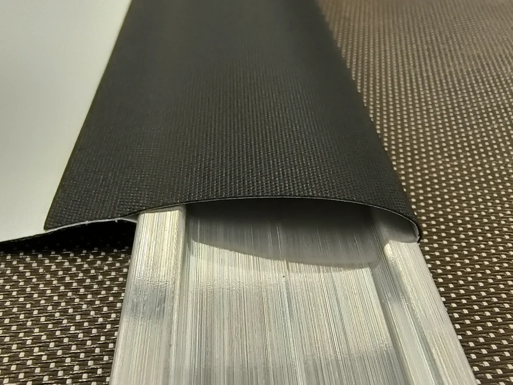 Aluminum hem bar inserted into welded roller shade fabric pocket